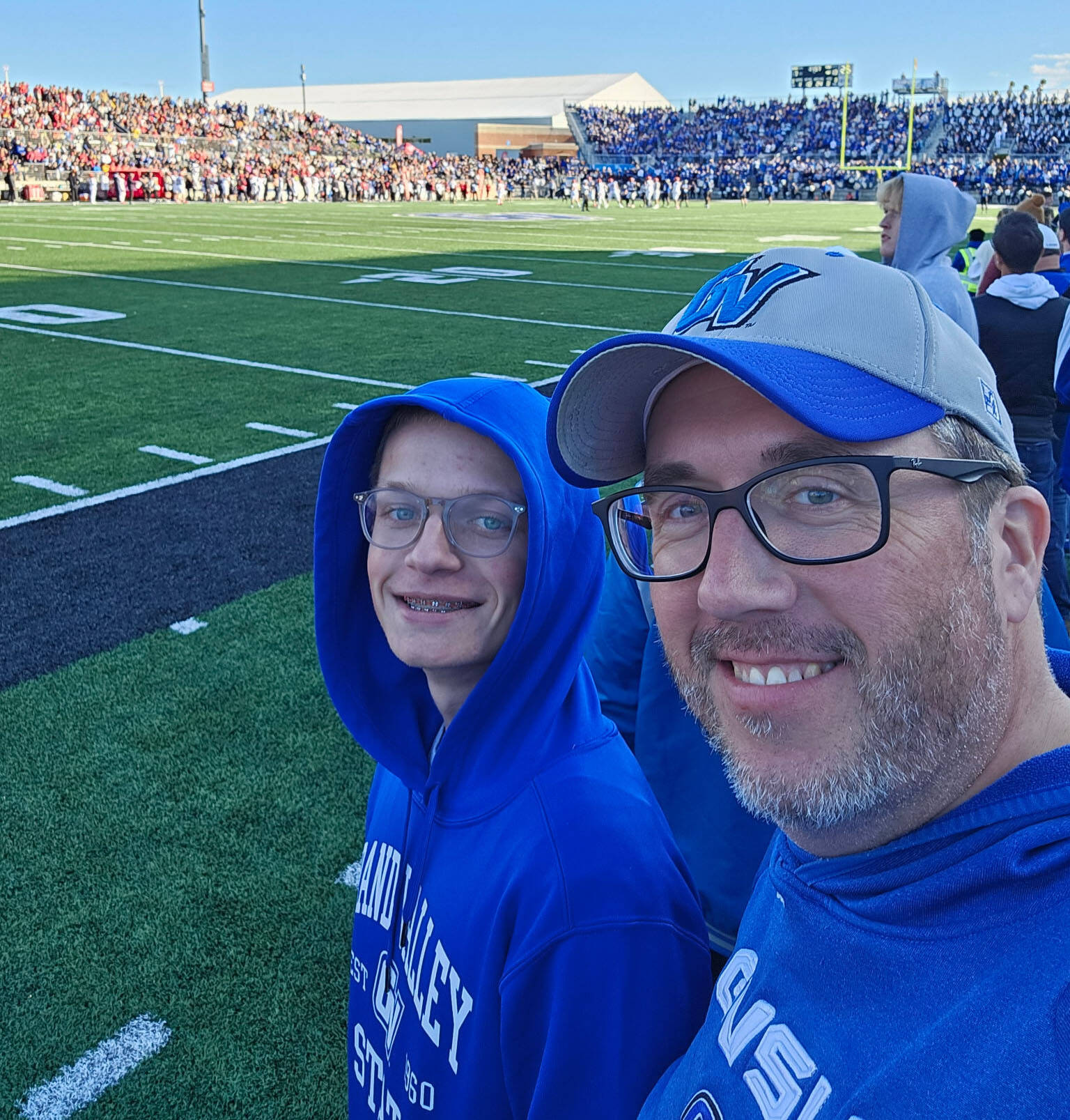 at GVSU football game are Mike Eichberger and his stepson Tristan, both are wearing Laker blue